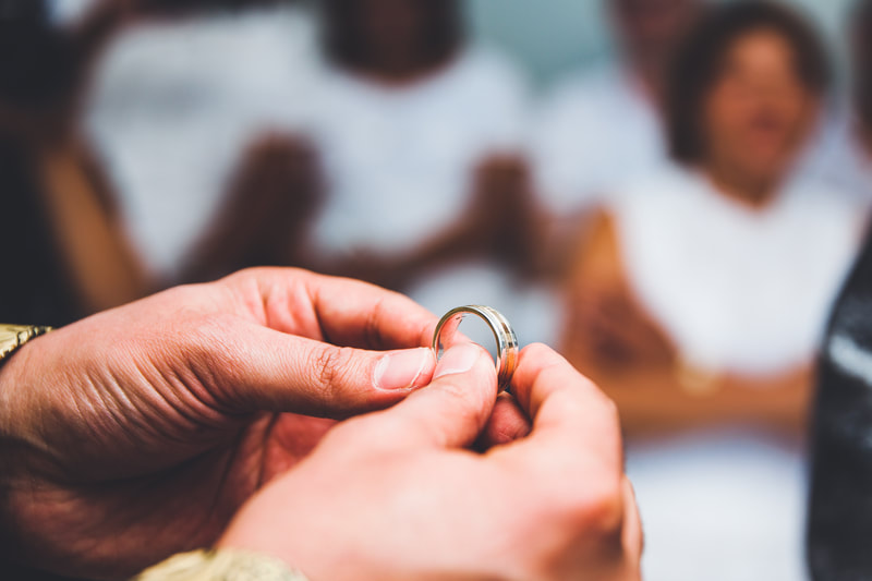 pastor's hands holding wedding rings